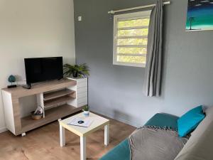 uma sala de estar com um sofá, uma televisão e uma mesa em Villas smoothie SYCARO em Le François