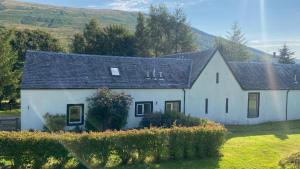 una gran casa blanca con techo negro en Exclusive private estate cottage en Lochearnhead