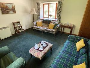 a living room with two couches and a table at Exclusive private estate cottage in Lochearnhead