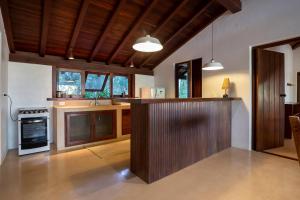 a kitchen with a counter and a stove top oven at Guest House - Praia de Itapororoca in Trancoso