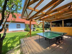 eine Tischtennisplatte unter einer Pergola in der Unterkunft KAPINA sk - Holiday Homes in Liptovská Sielnica
