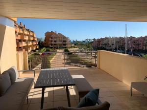 balcón con mesa y vistas a la ciudad en Sotogrande Ribera Marlin, en Sotogrande