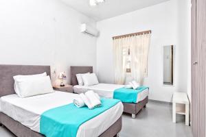 a bedroom with two beds and a window at Blue Violet Apartment in Drios