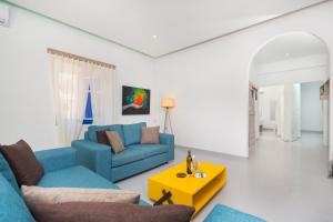 a living room with a blue couch and a yellow table at Blue Violet Apartment in Drios