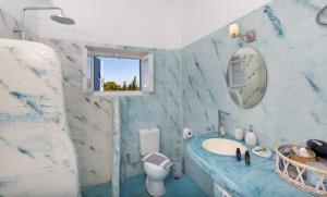 a blue and white bathroom with a sink and a mirror at Blue Violet Apartment in Drios +17 photos