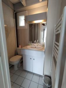 a bathroom with a sink and a toilet at Royan - Agréable Duplex Plage de Nauzan in Vaux-sur-Mer