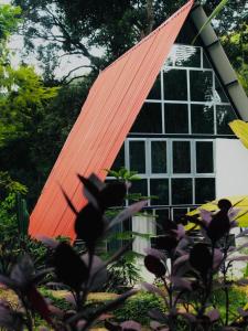 una casa con techo naranja y ventana en Riverston Nature Villa, en Rattota