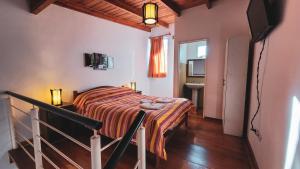 1 dormitorio con 1 cama y TV en Cálido Rincón en Villa Elisa