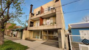 een appartementencomplex met een balkon in een straat bij Cálido Rincón in Villa Elisa