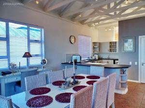 a kitchen with a table and chairs and a kitchen with a counter at Signature Lodge 3 @ Pinnacle Point Golf Estate in Mossel Bay