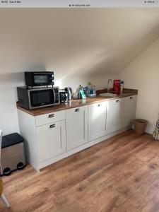 una cucina con forno a microonde e piano di lavoro di Drum Manor Apartment Hillsborough BT26 6PU a Hillsborough