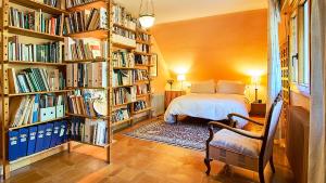um quarto com uma cama e prateleiras cheias de livros em Casa Julia 