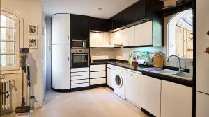 uma cozinha com armários a preto e branco e um lavatório em Casa Julia 