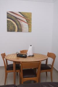 a wooden table with chairs and a laptop on it at Koring Residence at Dalaba Estate in Jabang