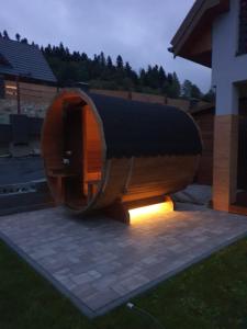 a round wooden building with a light in a yard at Domki Na Wzgórzu Słońce JACUZZI SAUNA ROWERY in Zawóz