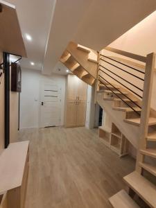 a large room with a wooden staircase in a house at Domki Na Wzgórzu Słońce JACUZZI SAUNA ROWERY in Zawóz