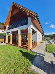 a home with a large yard with a patio at Domki Na Wzgórzu Słońce JACUZZI SAUNA ROWERY in Zawóz