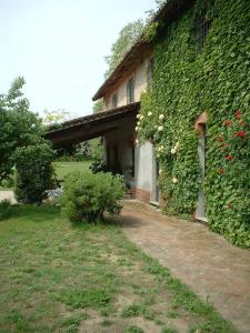 an ivy covered building with a pathway next to a yard at Country House in Zerbolò