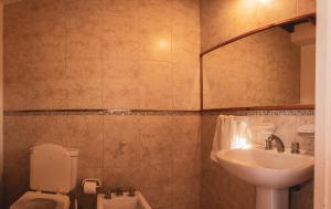 a bathroom with a toilet and a sink at Cálido Rincón in Villa Elisa