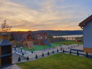een blik op een speeltuin met een huis bij Dom na Wzgórzu SŁOŃCE na wyłączność JACUZZI ELEKTRYCZNE SAUNA ROWERY in Zawóz