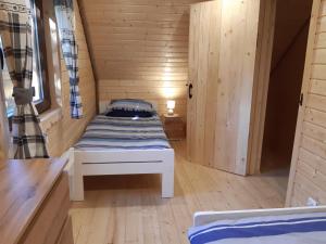 a small room with a bed in a tiny house at Domek na Pętli in Hoczew