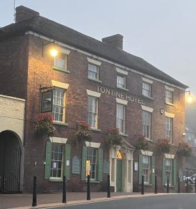 um edifício de tijolos vermelhos com o hotel em linha urbana numa rua em The Tontine Hotel & Bar em Ironbridge