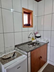 uma cozinha com um lavatório e uma bancada em Estalagem Do Luar em Monte Verde