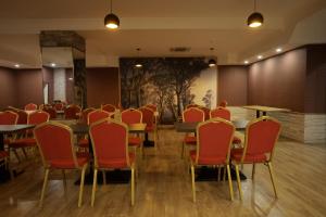 a restaurant with red chairs and tables in a room at Redline Hotel in Tbilisi City