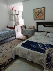 a bedroom with two beds and a table and a chair at Hostel Cantinho da Paz in Caxambu