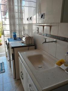 a kitchen with a sink and a counter top at Hostel Cantinho da Paz in Caxambu