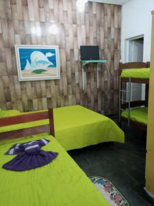 Pokój z 2 łóżkami i laptopem na ścianie w obiekcie Hostel Cantinho da Paz w mieście Caxambu