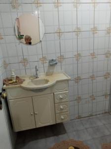 W łazience znajduje się umywalka i lustro. w obiekcie Hostel Cantinho da Paz w mieście Caxambu