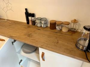 a wooden counter top with cups and bottles on it at Cosy City Cottage in Gaborone