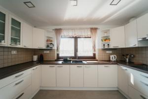 una cocina con armarios blancos y una ventana en Apartmán Na Palouku Povrly, en Povrly