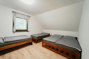 2 camas individuais num quarto com uma janela em Apartmán Na Palouku Povrly em Povrly