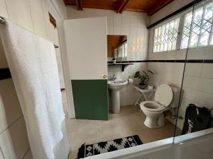 a bathroom with a toilet and a sink at Cosy City Cottage in Gaborone +23 photos
