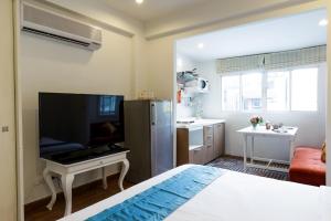 1 dormitorio con 1 cama y cocina con nevera en Arawana Residence Phromphong en Khlong Toei