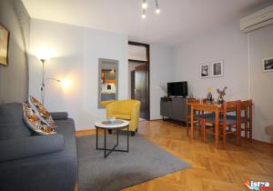 un soggiorno con divano e tavolo di Dr. IGDA Apartments a Poreč (Parenzo)