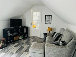 a living room with two chairs and a tv at Green Little Acre in Little Singleton