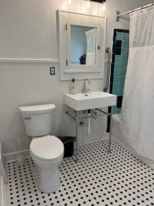 a bathroom with a white toilet and a sink at Cute yellow 2-BR bungalow w/free garage, free WiFi in Milwaukee