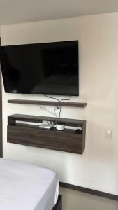 a flat screen tv on a wall in a bedroom at Valle del lili cozy apartment in Cali