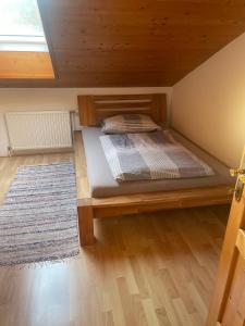a bedroom with a wooden bed with a rug at Ferienwohnung ,Hoizmann` in Pinsdorf