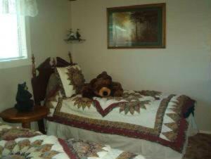 un osito de peluche sobre una cama en BEAR CABIN GETAWAY!!!(SPA) Pet Friendly Backyard, en Big Bear City