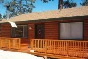 a wooden cabin with a porch and a door at BEAR CABIN GETAWAY!!!(SPA) Pet Friendly Backyard in Big Bear City