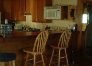 twee stoelen aan een aanrecht in een keuken bij BEAR CABIN GETAWAY!!!(SPA) Pet Friendly Backyard in Big Bear City