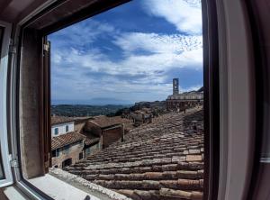 een raam met uitzicht op de ruïnes van het theater bij Casa Sant'Ercolano in Perugia