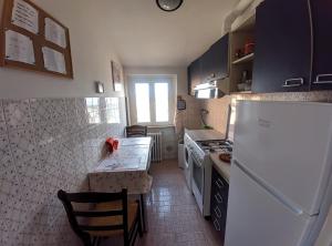 Una cocina con un refrigerador y una mesa dentro. en Casa Sant'Ercolano, en Perugia