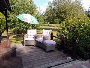 2 chaises et un parasol sur une terrasse en bois dans l'établissement JustB, à Riemst