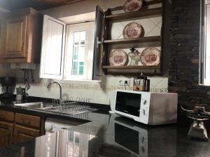 a kitchen with a microwave and a counter top at Casa Retiro de Xisto II in Videmonte