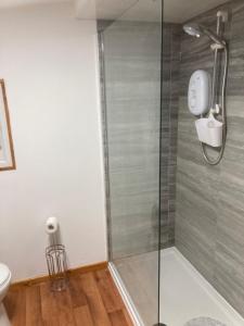 a shower with a glass door in a bathroom at Cherry Croft Lodge in Little Singleton